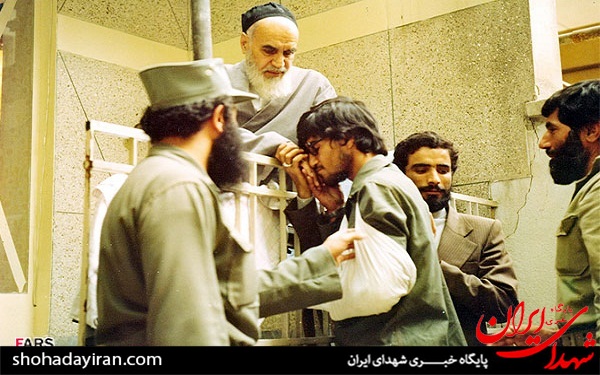 بوسه رزمنده مجروح بر دستان امام(ره)+عکس