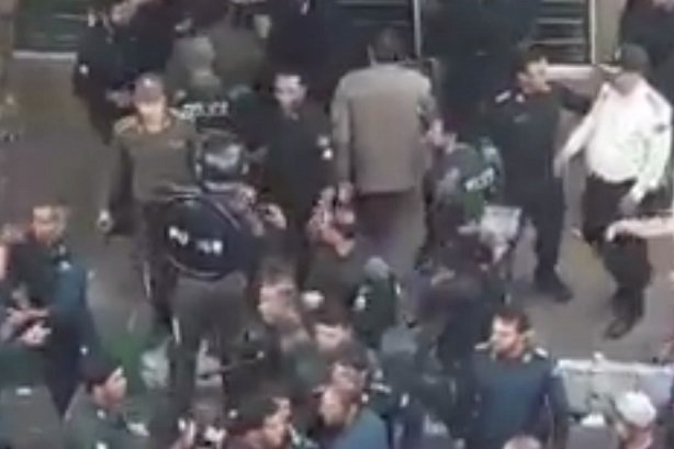 برخورد پلیس با مأموران خاطی در تجمع خیابانی