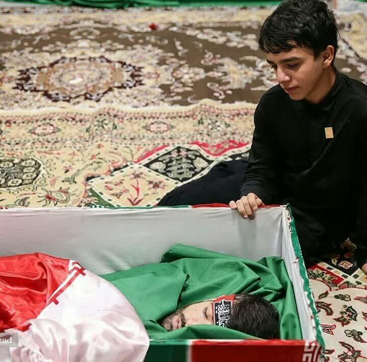 نگاه پرمفهوم فرزند شهید مدافع حرم به پیکر مطهر پدر...!